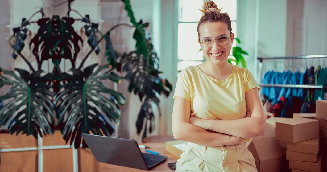 Junge lächelnde Kleinunternehmerin in ihrem Büro