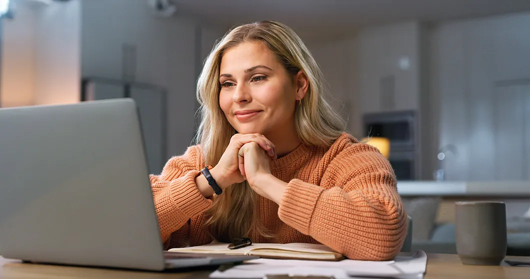 Glückliche Frau zu Hause am Laptop